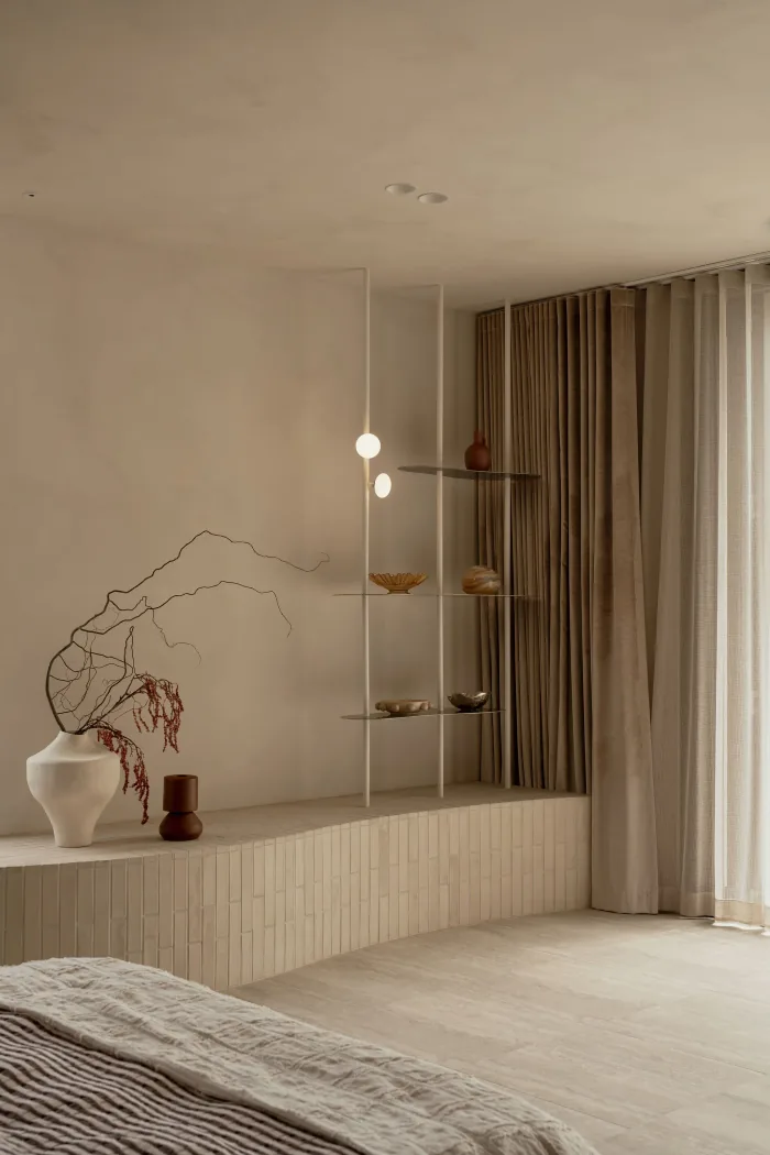 A sculptural branch arrangement and open shelving in a ZOEI bedroom.