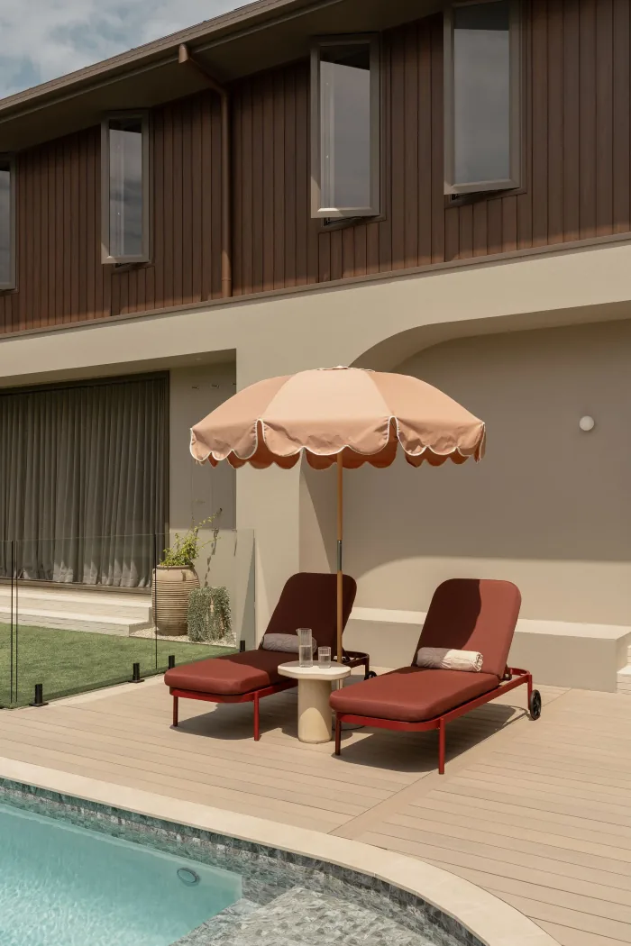 Loungers under a scalloped umbrella on the ZOEI pool deck.