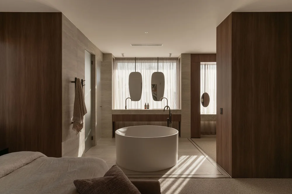 A freestanding stone bath in a travertine bathroom at ZOEI, suited to beauty and skincare campaigns.