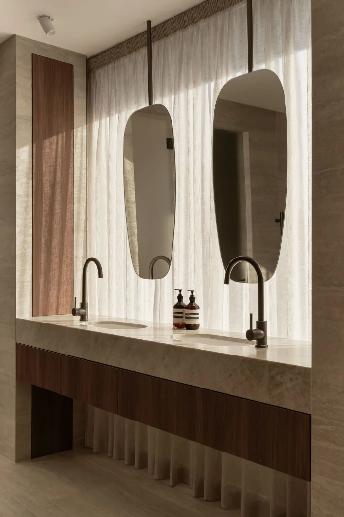 A double stone vanity with sculptural mirrors at ZOEI.