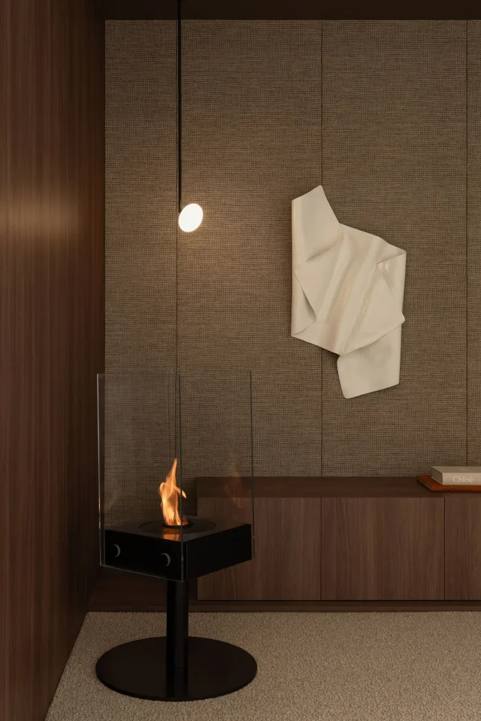 A quiet corner with a tabletop fire and textured wall at ZOEI.