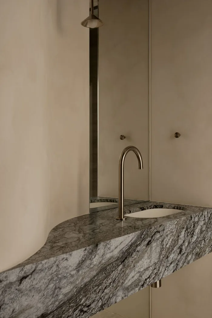A veined marble vanity and slim tapware in a ZOEI bathroom.