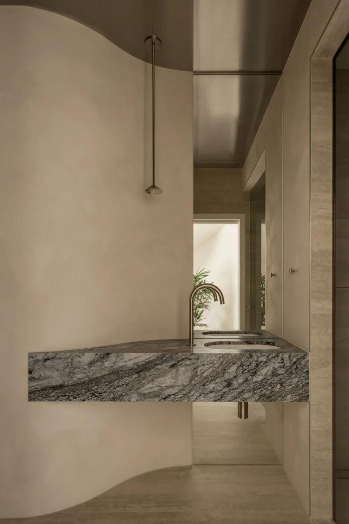 The powder room at ZOEI with a curved marble basin.
