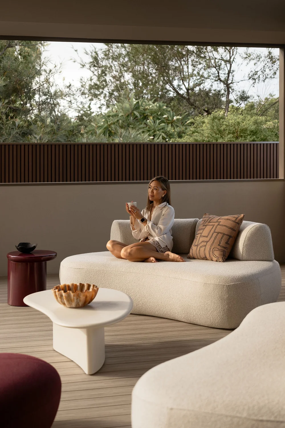 Talent seated on a curved outdoor sofa in the alfresco area at ZOEI on the Gold Coast.